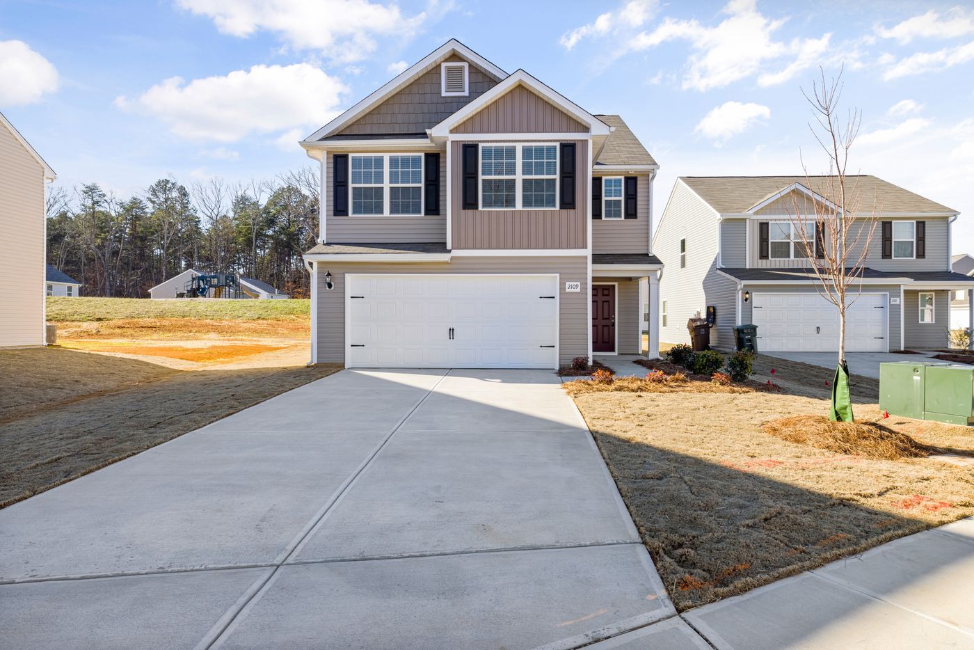 New concrete driveway in front of a two-story house