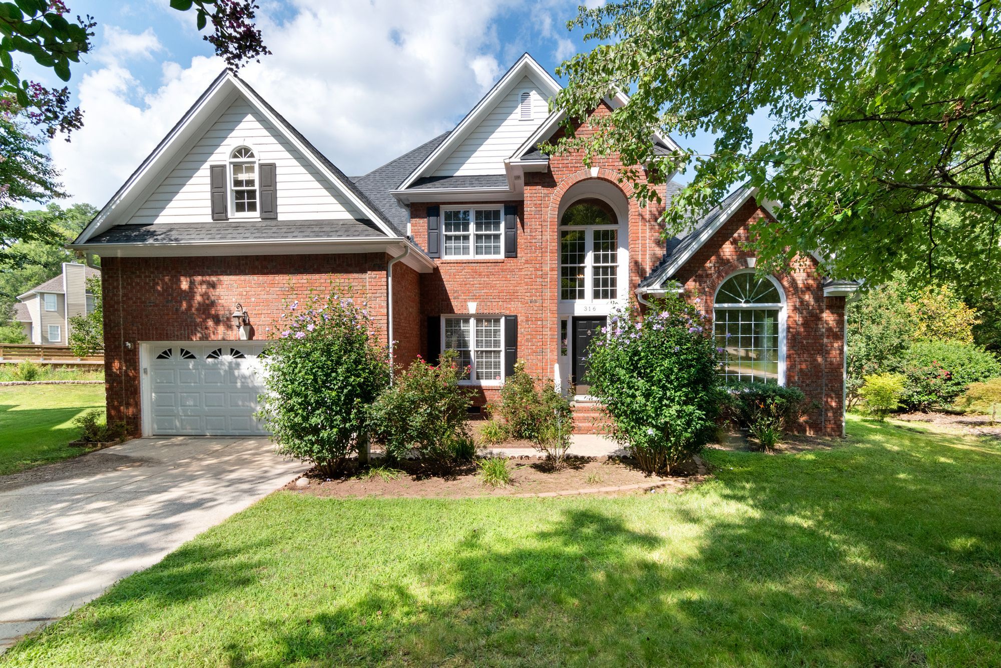 Two-story red-brick house with an asphalt shingle roof