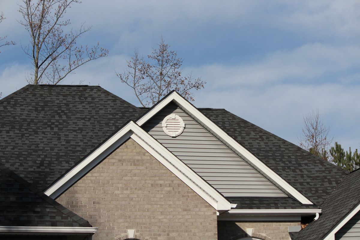 Dark architectural shingles on a brick and siding house
