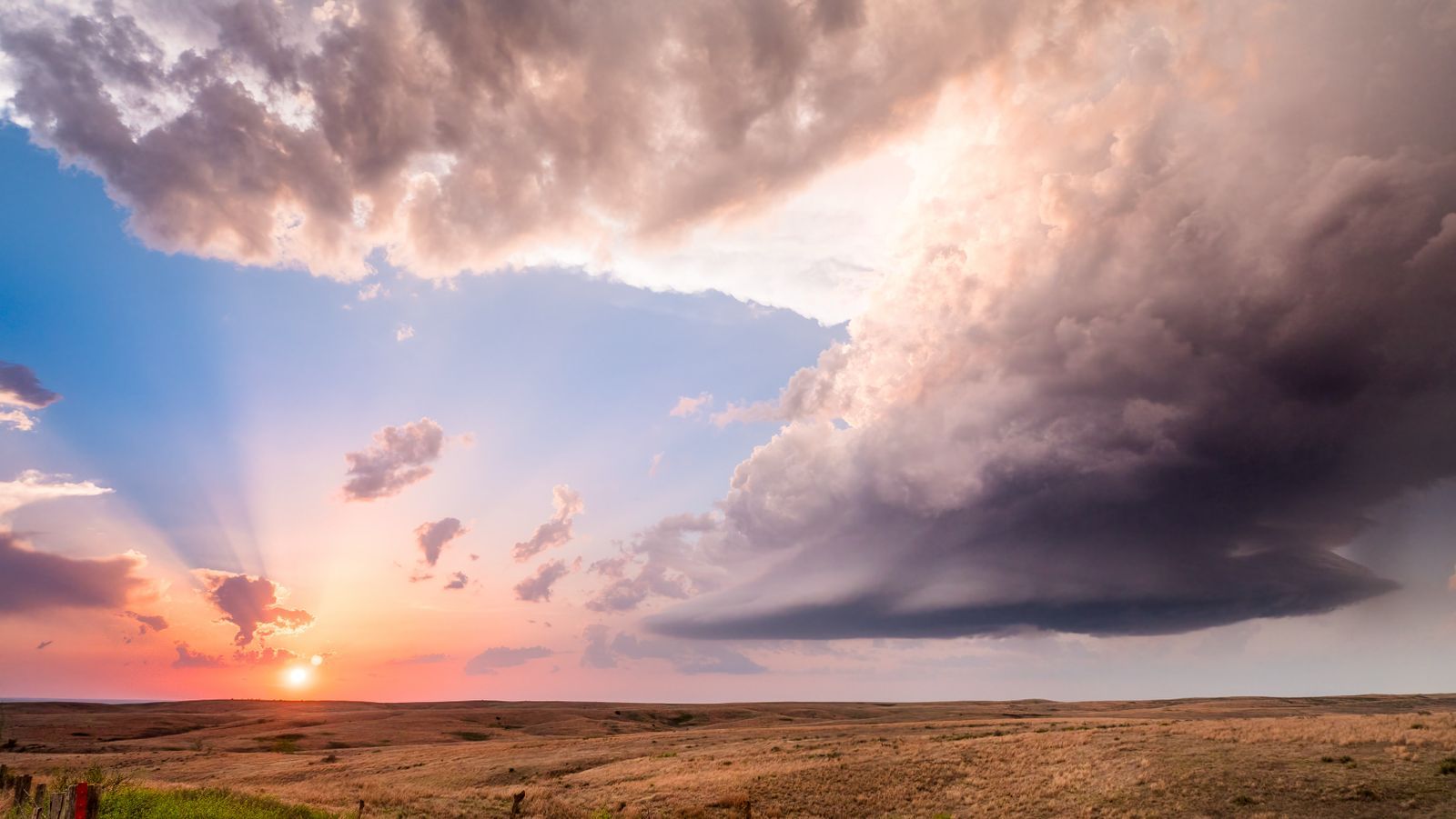 A storm cell over open prairie at sunset
