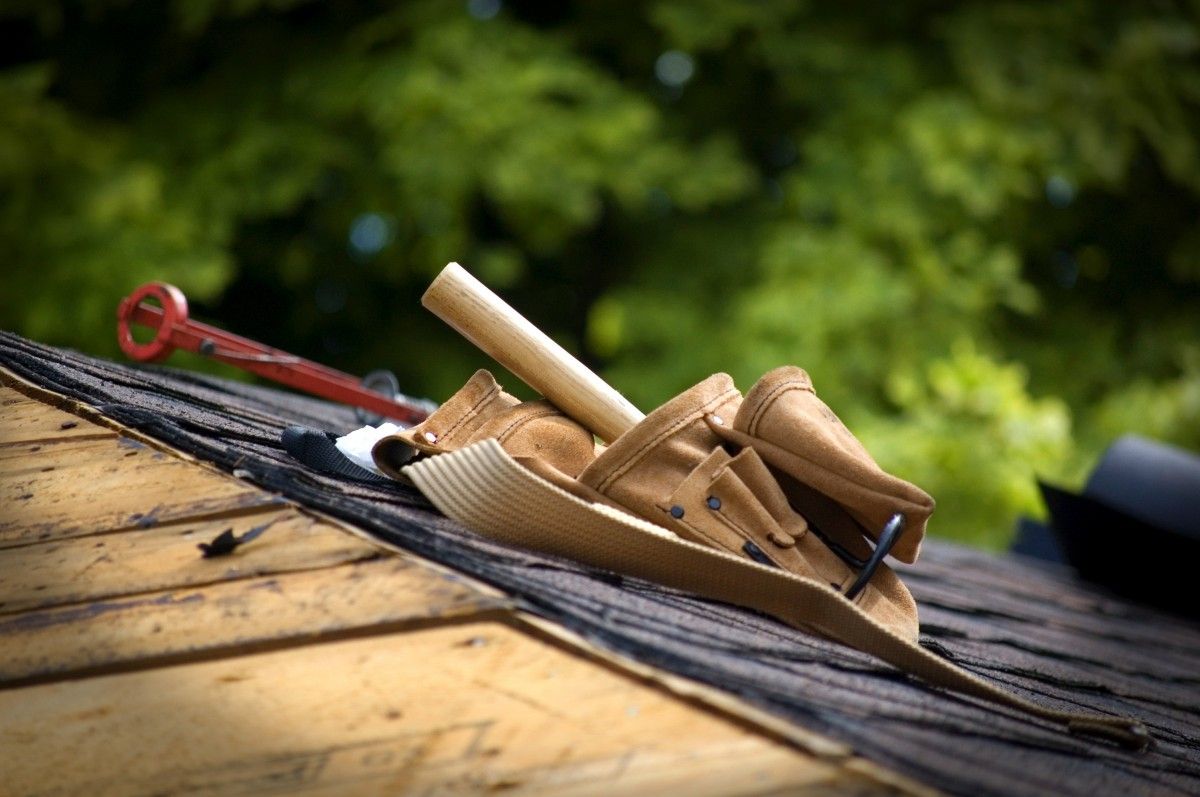 Tool belt and hammer on an asphalt shingle roof